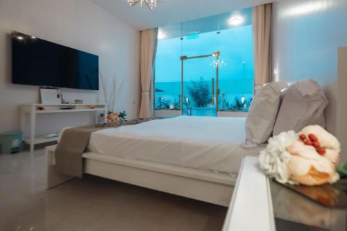 ein Schlafzimmer mit einem großen Bett und einem großen Fenster in der Unterkunft سيلين وسيلينا in Al Barkah