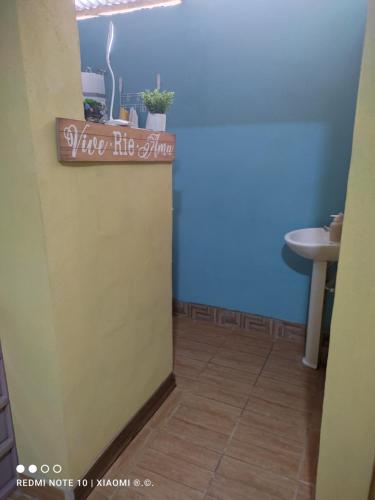 La salle de bains est pourvue d'un lavabo et d'un panneau indiquant une ambiance un peu étrangère. dans l'établissement IsmaRoom, à El Remate