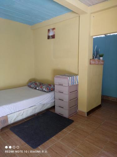 a small bedroom with a bed and a dresser at IsmaRoom in El Remate