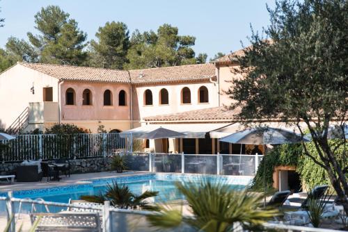 a resort with a swimming pool and a building at Logis Hostellerie De L'Abbaye in Le Thoronet