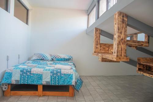 1 dormitorio con 1 cama con edredón azul en Las Carmelas, Airport Juan Santamaría, Alajuela, San José en Alajuela