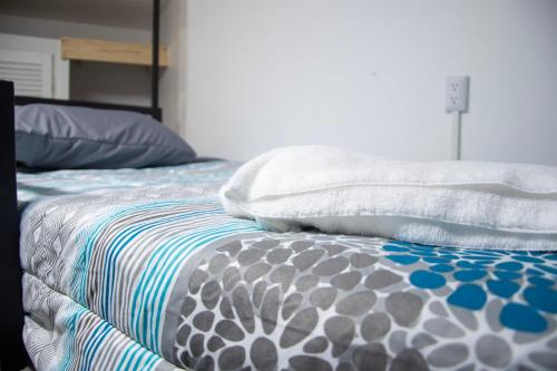 a bed with two pillows on top of it at Las Carmelas, Airport Juan Santamaría, Alajuela, San José in Alajuela City