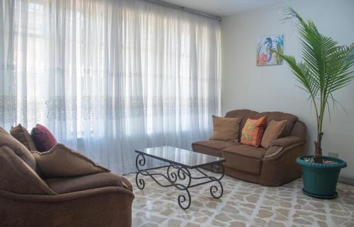 a living room with two couches and a coffee table at Las Carmelas, Airport Juan Santamaría, Alajuela, San José in Alajuela City