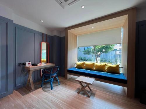 a room with a window with a blue bench at Banlansuan Resort SHA Plus in Cha Am