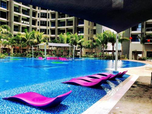 a large swimming pool with pink lounge chairs in it at ATLANTIS CITYVIEW 1BR Residence I Jonker I TV Box I Free WIFI in Melaka