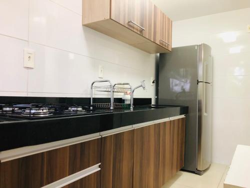 a kitchen with a black counter top and a refrigerator at Tambaú Home Beira Mar - com varanda in João Pessoa