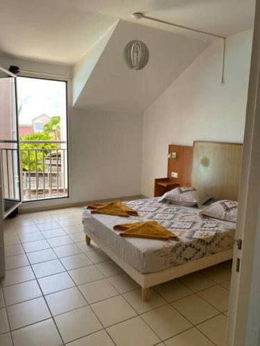 una camera da letto con un letto e una grande finestra di Maison Agréable Familiale a Saint-François