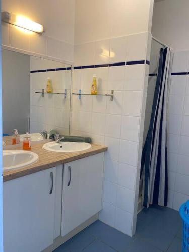 un bagno con lavandino e specchio di Maison Agréable Familiale a Saint-François