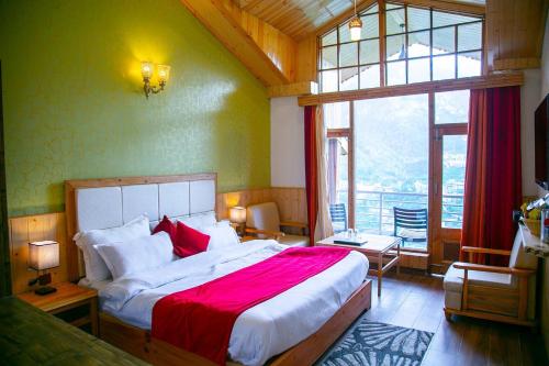 a bedroom with a large bed and a large window at Hotel Seven Hills Manali in Manāli