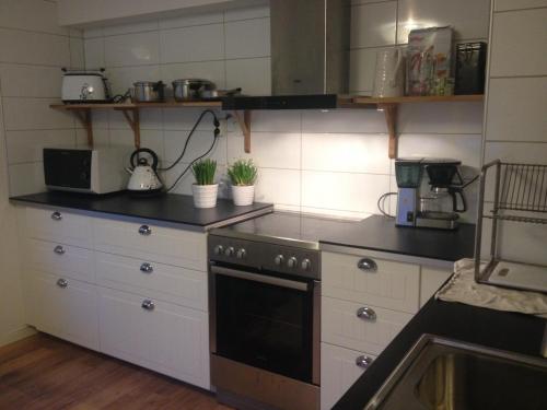 a kitchen with white cabinets and a stove top oven at Möllegården Bed & Breakfast in Tyringe