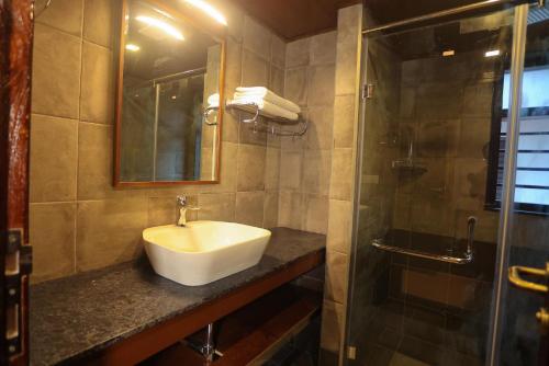 uma casa de banho com um lavatório e um chuveiro em Heaven Inn Munnar em Munnar