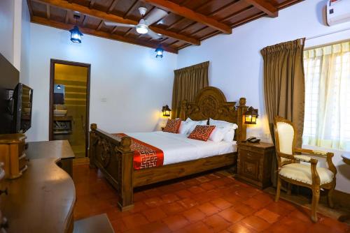 um quarto com uma cama, uma secretária e uma cadeira em Heaven Inn Munnar em Munnar