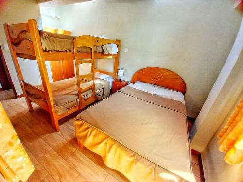 a bedroom with two bunk beds in a room at Yuyay Wasi Bungalows in Urubamba