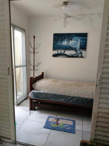 een slaapkamer met een bed en een schilderij aan de muur bij Apartamento em Maranduba - Ubatuba in Ubatuba