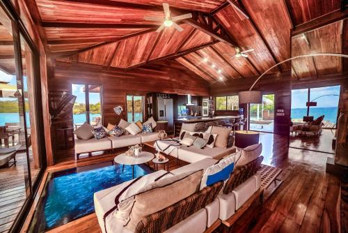 een woonkamer met een zwembad in het midden bij Eco-Lodge Bocas Coral Reef - Over water villa & birds house in Botabite