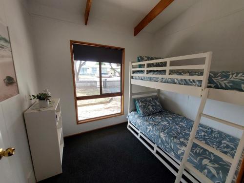 Zimmer mit 2 Etagenbetten und einem Fenster in der Unterkunft Karoa in Wallaroo