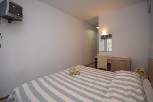 a bedroom with a bed with a pair of shoes on it at Myrtis Spa Hotel in Plakias