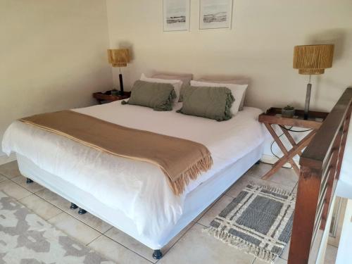 a bedroom with a large white bed with two lamps at 625 on Marine - 5 min from beach in Durban