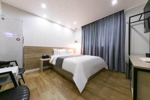 Habitación de hotel con cama y escritorio en Daejeon Yuseong Hotel Dret en Daejeon