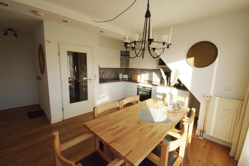 a kitchen and dining room with a wooden table and chairs at Borkum in Dorum Neufeld