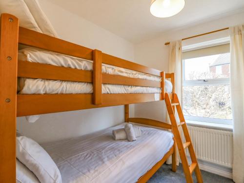 2 Etagenbetten in einem Zimmer mit einer Leiter in der Unterkunft Sea Pebbles in Weymouth