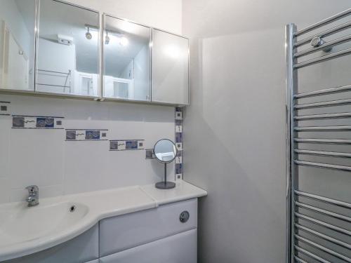 ein Badezimmer mit Waschbecken und Spiegel in der Unterkunft Sea Pebbles in Weymouth