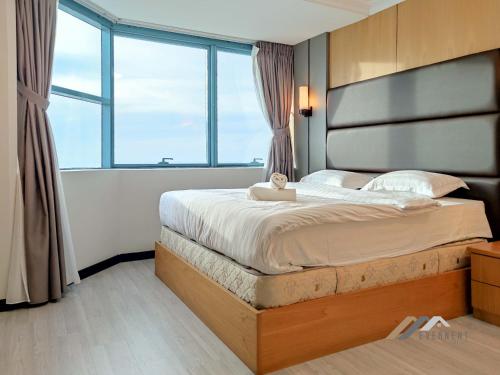 a bedroom with a large bed with a large window at Imperial Suites by Evernent in Miri