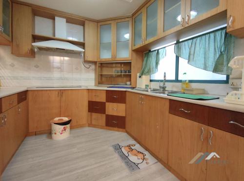 una cocina con armarios de madera y fregadero en Imperial Suites by Evernent en Miri