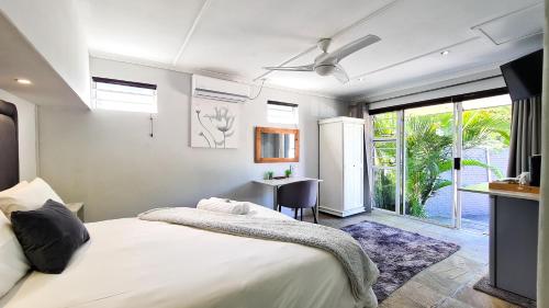 a bedroom with a bed and a desk and a window at Lido Living in East London