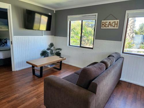a living room with a couch and a table at Surfrider Caravan Park in Barrack Point