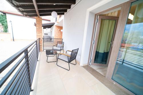 a balcony with chairs and a glass door at First Apartments in Focşani