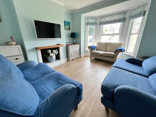 a living room with two blue couches and a tv at RedButt House, Freshwater, 3 Bedrooms, WiFi, Garden in Freshwater