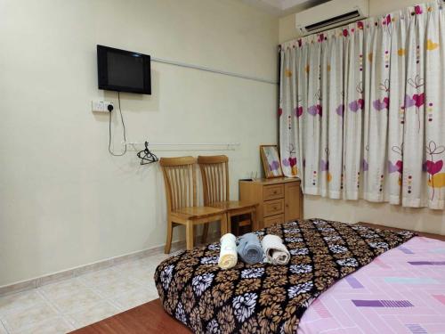 een slaapkamer met een bed, een stoel en een televisie bij OYO HOME 90764 Coke Guest House in Masjid Tanah