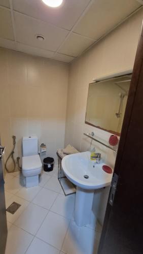 a bathroom with a sink and a toilet and a mirror at Nice big Studio Casino view first line in Ras al Khaimah