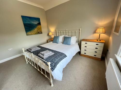 een slaapkamer met een wit bed en een dressoir bij RedButt House, Freshwater, 3 Bedrooms, WiFi, Garden in Freshwater