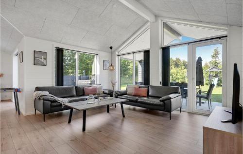 a living room with two couches and a table at Lovely Home In Glesborg With Sauna in Glesborg