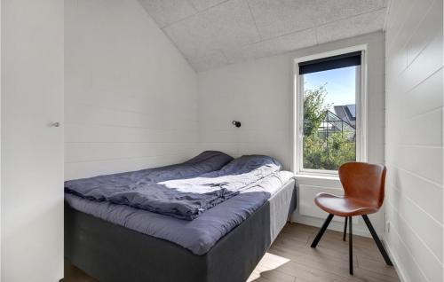 Beautiful Home In Glesborg With Wifi في Glesborg: سرير في غرفة بها كرسي ونافذة