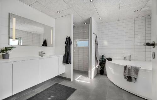 Beautiful Home In Glesborg With Wifi في Glesborg: حمام أبيض مع حوض ومغسلة