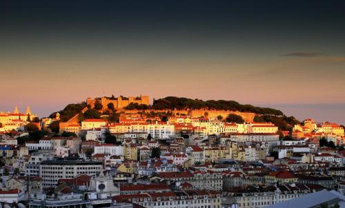 a view of a city with a castle on a hill at Hotel Lis Baixa in Lisbon