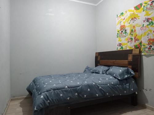 Un dormitorio con una cama con almohadas azules. en Casa Huamanga en Ayacucho