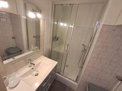 biała łazienka z prysznicem i umywalką w obiekcie T2 - Centre ville - proche plage w mieście Bormes-les-Mimosas