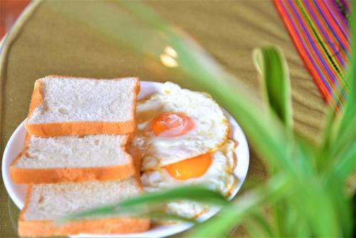 a sandwich with an egg on a plate on a table at Hmong Eco Villas in Sa Pa