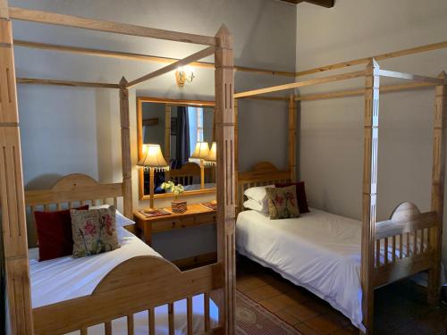 a bedroom with two bunk beds and a mirror at Port Wine Guesthouse in Calitzdorp