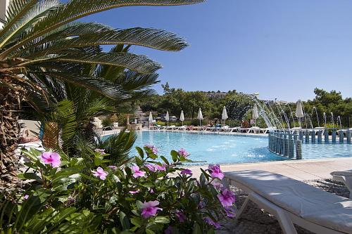 a swimming pool with pink flowers and a fountain at Stella View Studios in Pefki Rhodes