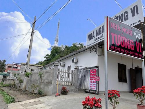 ein weißes Gebäude mit einem Schild davor in der Unterkunft Nhà Nghỉ Tường Vi in Bắc Quang