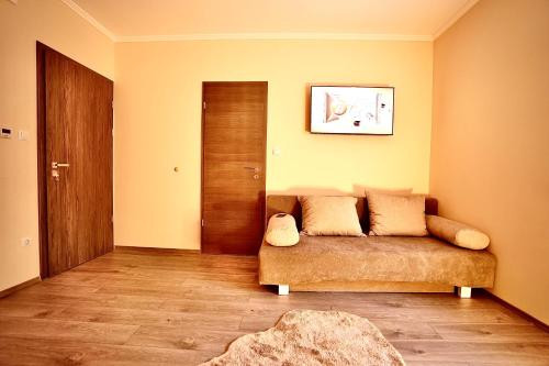 sala de estar con sofá y puerta de madera en Bacchus Pub és Panzió en Dunaharaszti
