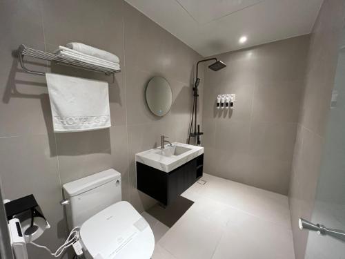 a bathroom with a toilet and a sink and a mirror at GD Hotel in Yeosu