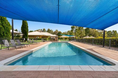 a blue swimming pool with a blue tent over it at Leisure Inn Pokolbin Hill in Pokolbin