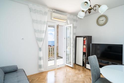 sala de estar con mesa y reloj en la pared en Apartment Debos, en Dubrovnik