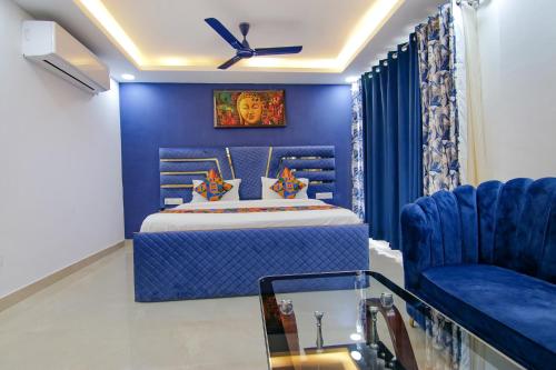 - une chambre bleue avec un lit et une chaise bleue dans l'établissement FabHotel Satyam International, à Noida